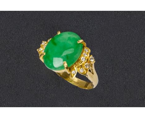 A CABOCHON JADE AND DIAMOND RING
Set in unmarked gold, the central cabochon jade flanked with seven round cut diamonds to eac