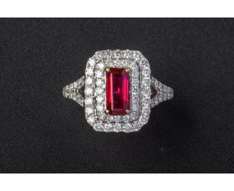 A RUBY AND DIAMOND RING
Set in 18k white gold, the step cut ruby with a double border of round brilliant cut diamonds and dia