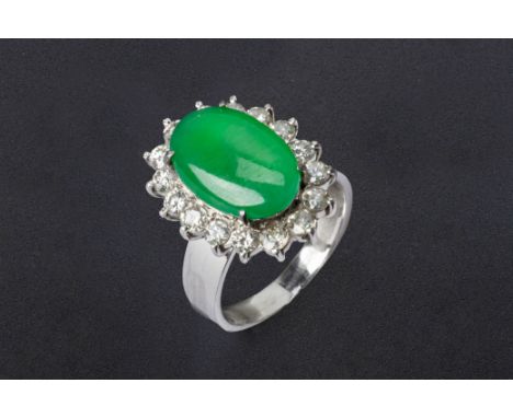 A JADE AND DIAMOND CLUSTER RING
Set in 18k white gold, the central oval jade cabochon within a round brilliant cut diamond su