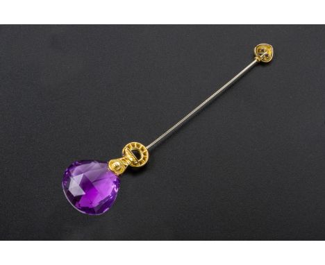 AN AMETHYST, RUBY AND DIAMOND PIN BY ANTONINI
Set in 18k gold, the large amethyst drop with a cabochon ruby and round brillia