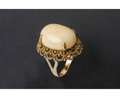 A LARGE CORAL RING Set in 14k gold, the oval cabochon within an openwork setting Marked '14k' US size 7.5 12.7g Condition: So