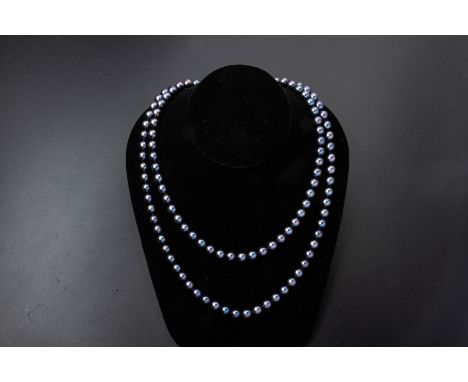 A CULTURED PEARL SINGLE STRAND NECKLACE
The long strand of uniform pearls with a silver clasp, likely dyed freshwater pearls 
