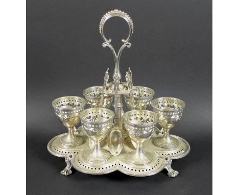 A Victorian silver egg cup stand with six egg cups, raised scroll form handle, all with pierced and engraved decoration, the 
