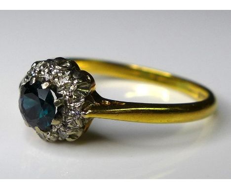 An 18ct yellow gold, sapphire and diamond flowerhead ring, the central stone surrounded by eight diamonds, size Q/R, 2.8g. 