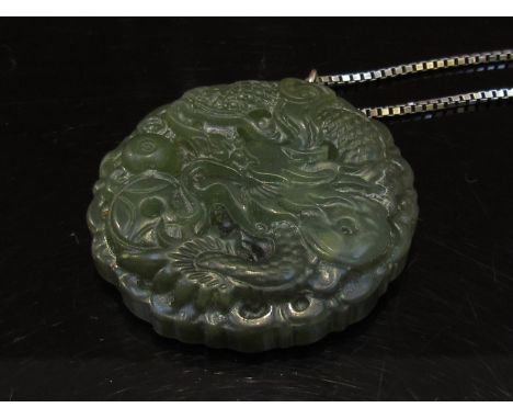 A large jade dragon pendant 4.5cm diameter hung on a box chain stamped 925, 62cm long