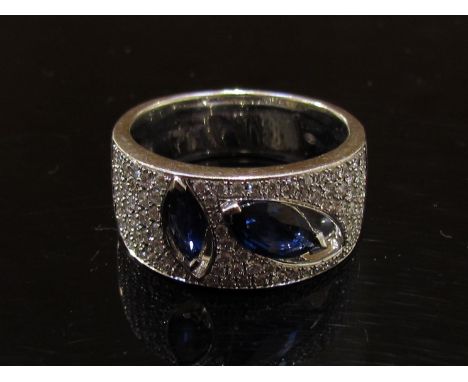 A white gold diamond and sapphire modernist design ring stamped 14K. Size N, 3g