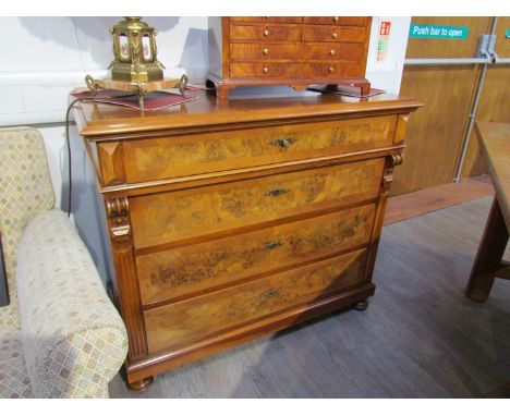 A French burr and figured walnut four drawer chest with key having corbel and reeded decoration over a plinth base on turned 