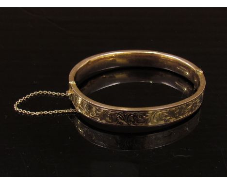 A 9ct rose gold stiff hinge bangle with engraved decoration, 11g
