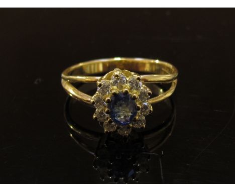 A 14ct gold sapphire and diamond ring, the central sapphire framed by diamonds. Size P, 3.3g