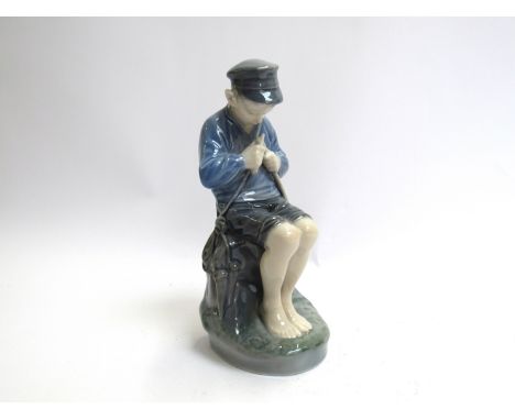 A Royal Copenhagen figure of a boy sharpening a stick, 18.5cm tall