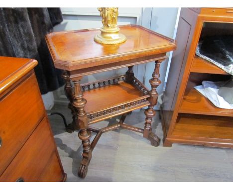 A Victorian walnut two tier lamp table on turned and reeded supports with turned spindle gallery under-tier over a "Y" stretc
