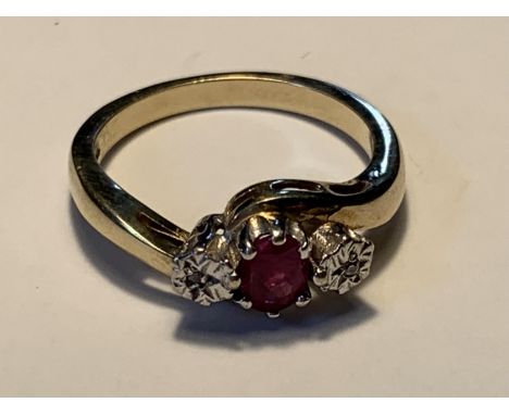 A 9 CARAT GOLD RING WITH A CENTRE RUBY AND A DIAMOND EACH SIDE SIZE L 