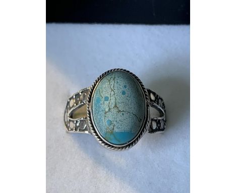 A SILVER RING WITH AN OVAL STONE SIZE R/S IN A PRESENTATION BOX 