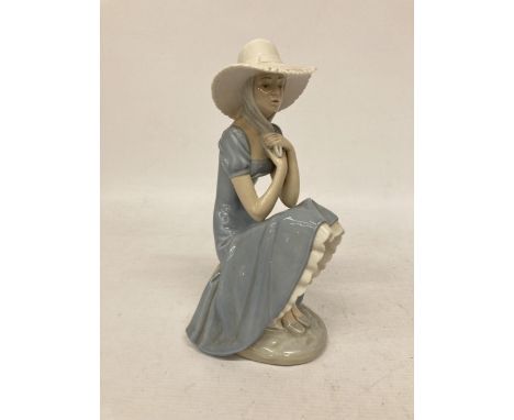 A NAO FIGURINE OF A PENSIVE GIRL IN LARGE SUNHAT SITTING ON A ROCK 