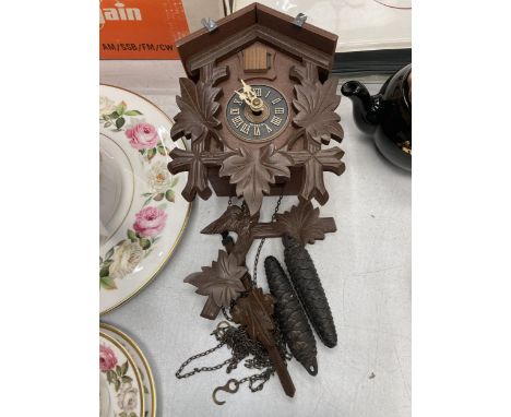 A WOODEN CUCKOO CLOCK WITH WEIGHTS 