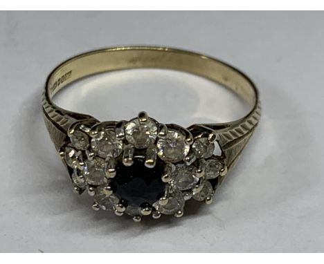 A 9 CARAT GOLD RING WITH A CENTRE SAPPHIRE SURROUNDED BY CUBIC ZIRCONIAS SIZE O/P 