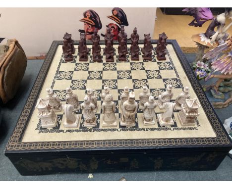 AN ORIENTAL THEMED CHESS SET AND BOARD, COMPLETE 