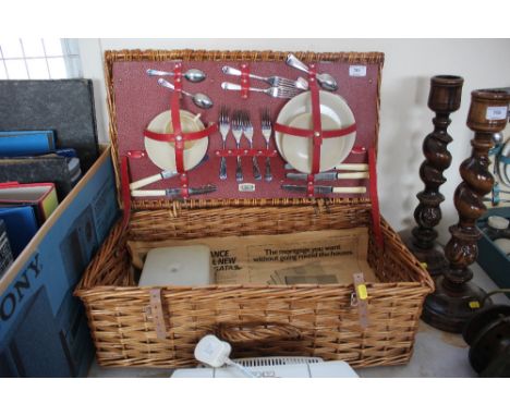 A wicker picnic hamper and contents
