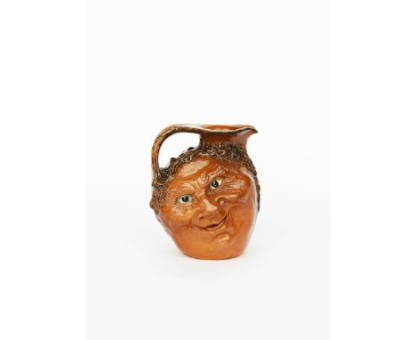 A Martin Brothers stoneware face jug by Robert Wallace Martin, dated 1903, modelled in low relief to one side with a smiling 