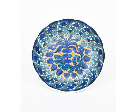 A John Pearson ceramic bowl, painted to the well with a radiating foliage design in shades of blue, highlighted in gilt on a 