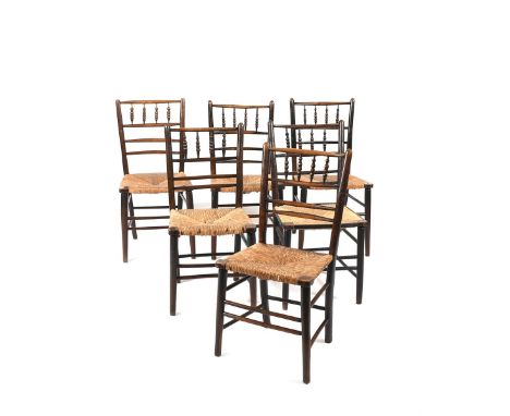 Six ebonised wood Sussex style chairs, possibly retailed by Liberty &amp; Co, with bobbin backs, rush seats, unsigned 87cm. h
