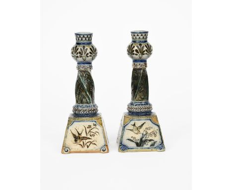 A pair of Martin Brothers stoneware candlesticks by Robert Wallace Martin, dated 1885, tapering square bases with twisted col
