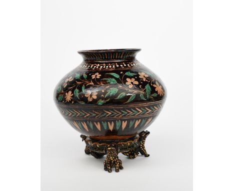 A Bombay School of Art Wonderland Pottery vase and stand, the ovoid  vase with everted top rim, painted with a band of flower