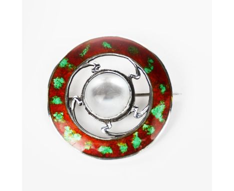 A silver and enamel brooch, pierced circular form, the rim with a band of red and green enamel, set to the centre with moonst