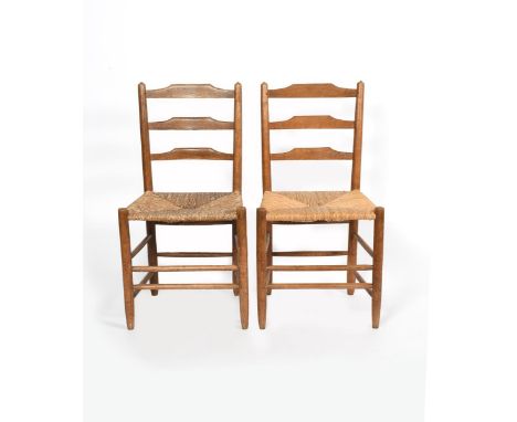 A pair of ash Clissett ladder back chairs designed by Neville Neal, with rush seat unsigned 88cm. high (2) Provenance Richard