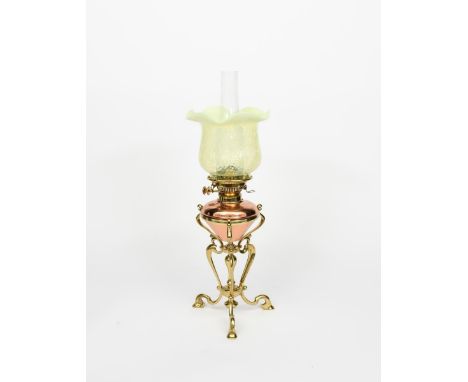 A copper and brass oil lamp in the manner of WAS Benson,  tripod scrolling brass base supporting copper reservoir, with glass
