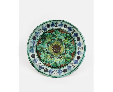 A Della Robbia Pottery plate by ELL, incised and painted with bands of stylised foliage, in shades of blue, green and yellow,