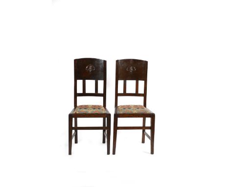 A pair of Liberty &amp; Co oak chairs designed by William Neatby, tapering square seat with  drop in cushion, the tapering ba