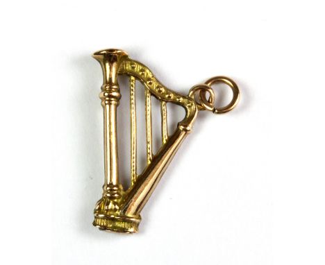A 9ct yellow gold harp shaped pendant, L. 2.3cm, (approx. 03.6gr).