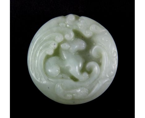 A 19th / early 20th century Chinese nephrite jade disc featuring a dragon on one side with a baby on its back and a dragon an