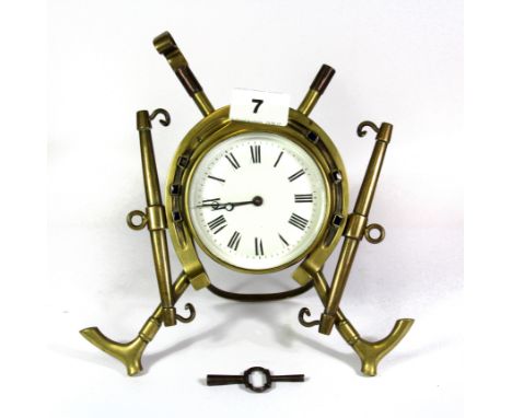 An interesting 19th century brass mantle clock in the form of a horse shoe and decorated with riding crops and heavy horse ha