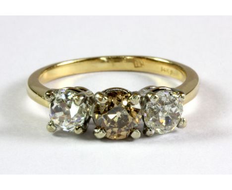 A 14ct yellow and white gold ring set with an old cut fancy light brown diamond flanked by two old cut white diamonds (N).