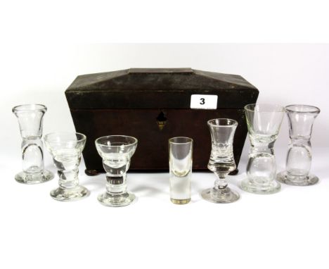 An early mahogany tea caddy with a collection of seven 18th and 19th century absinthe glasses.