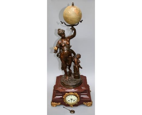 An early 20th figural mounted mantle clock with eight day cylinder movement. The mount in the form of a muse holding aloft a 