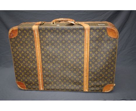 A large vintage Louis Vuitton suitcase with distinctive all over LV motif. 79 x 54cm  Formally the property of the late Jessy