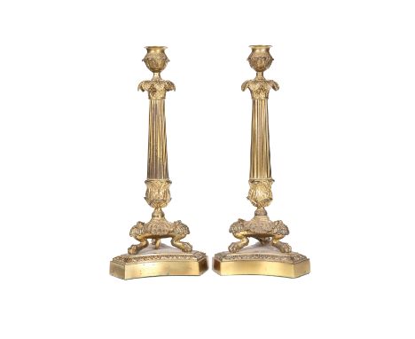 A PAIR OF GILT-METAL COLUMNAR LAMP BASES IN THE EMPIRE TASTE, each candle cup above a foliate drip pan on a fluted leaf-cast 