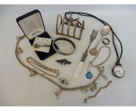 A silver toastrack, a heavy silver watch chain, various charms attached, silver pocket watch, silver brooches etc.