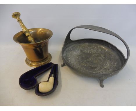 An early 19th Century brass mortar and pestle, an Arts and Crafts style pewter basket and a cased pipe.