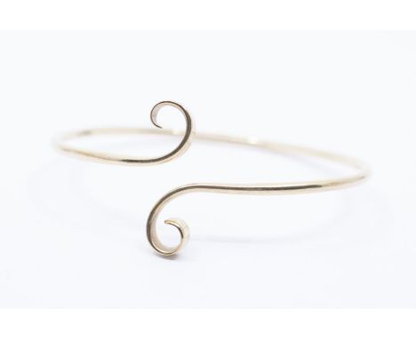 A 9ct gold torque slave bangle, round wire with scrolled terminal, internal diameter approx 8.5cm, weight approx 26.7gms Furt