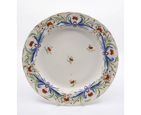 A Derbyshire fluted dinner plate, decorated with foliage tied together with a puce ribbon, the deep plate marked in puce with