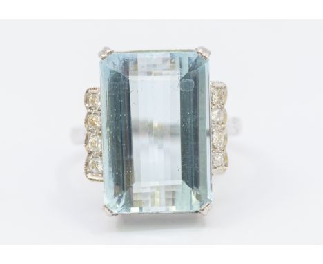 An aquamarine and diamond 18ct white gold cluster ring, comprising a rectangular step cut aquamarine to the centre approx 11 