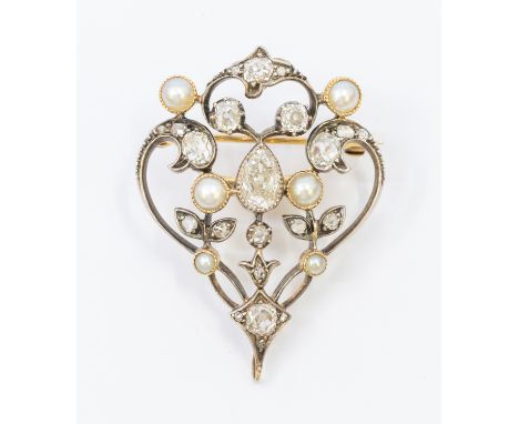 A Belle Epoque diamond and pearl set gold brooch comprising a open wire scrolled form decorated with grain set diamonds, with