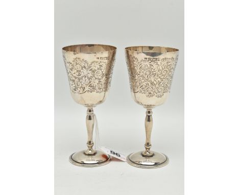 A PAIR OF ELIZABETH II SILVER GOBLETS, foliate engraved pattern to the cup with vacant cartouche, gilt interior, on round bas