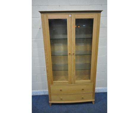 A SOLID LIGHT OAK BOW FRONT BOOKCASE, the double glazed doors enclosing three glass shelves, above two drawers, width 111cm x