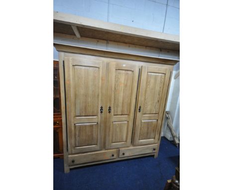 A LARGE GOOD QUALITY LIGHT OAK TRIPLE DOOR WARDROBE, with a fixed cornice, an arrangement of internal shelves and two long dr