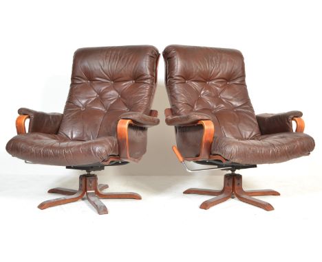 A pair of retro vintage 1970's leather pad swivel / easy / lounge chairs / armchairs . Each chair having a brown buttoned lea